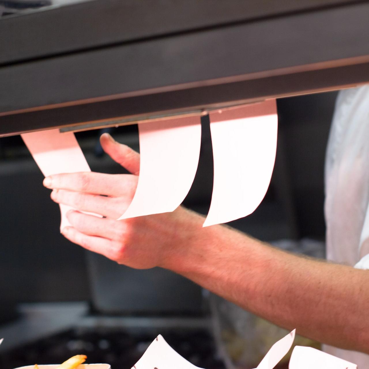 man holding white menu